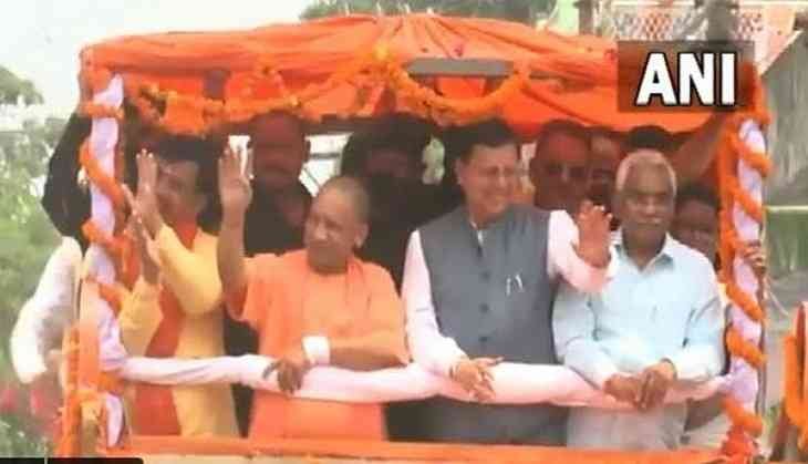 CM Pushkar Singh Dhami holds a roadshow along with UP CM Yogi Adityanath in Champawat.